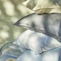 The evening sun shining onto a stack of pillows with Slumber Cloud Performance Pillowcases