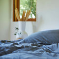 The evening sun shining onto a bed made with Slumber Cloud products