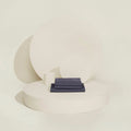 A neatly folded Slumber Cloud Performance Sheet Set in slate on a cream background