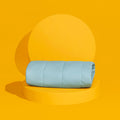 The temperature regulating Core Mattress Pad from Slumber Cloud propped on a yellow background