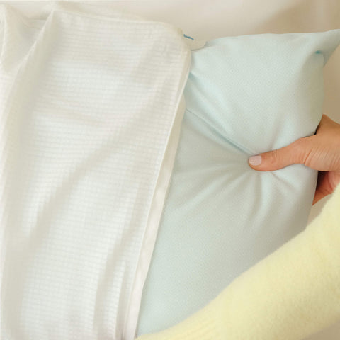 Woman inserting the Slumber Cloud UltraCool Pillow into the Slumber Cloud Performance Pillow Cover made with Outlast Temperature Regulation Technology